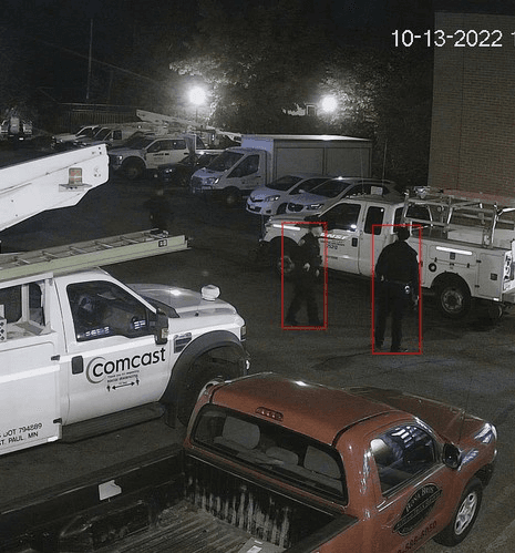 Night camera frame with two intruders detected in a vehicle yard